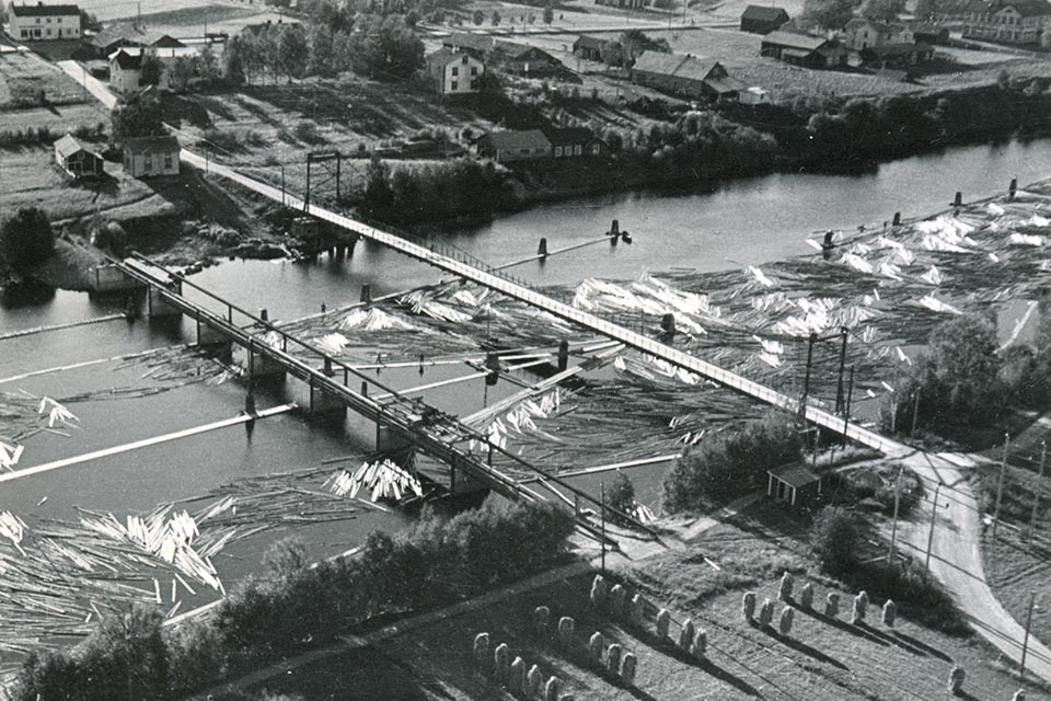 Flottningsdammen och hängbron över Lillån. Nuvarande bro uppfördes uppströms hängbron på 1970-talet. Umeå Flottningsförenings arkiv, Folkrörelsearkivet i Västerbotten.