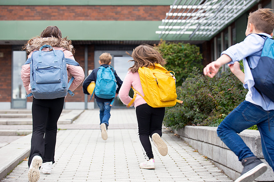 Skolbarn springer till skolan.