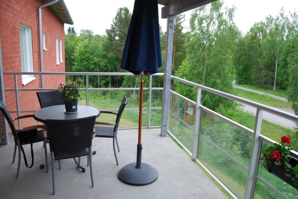 Balkong med sittplatser och parasoll