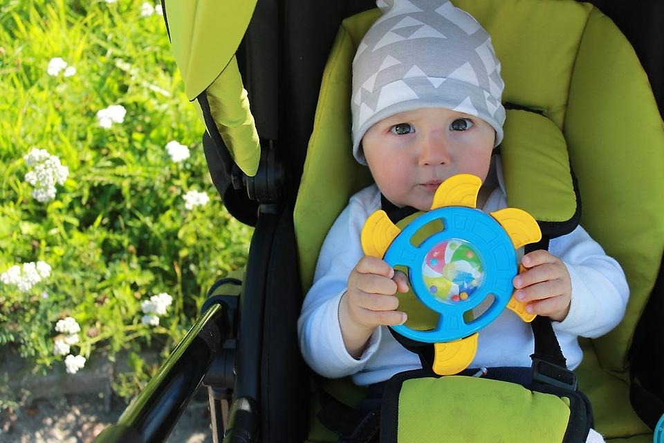 Foto av baby med en leksak i munnen.