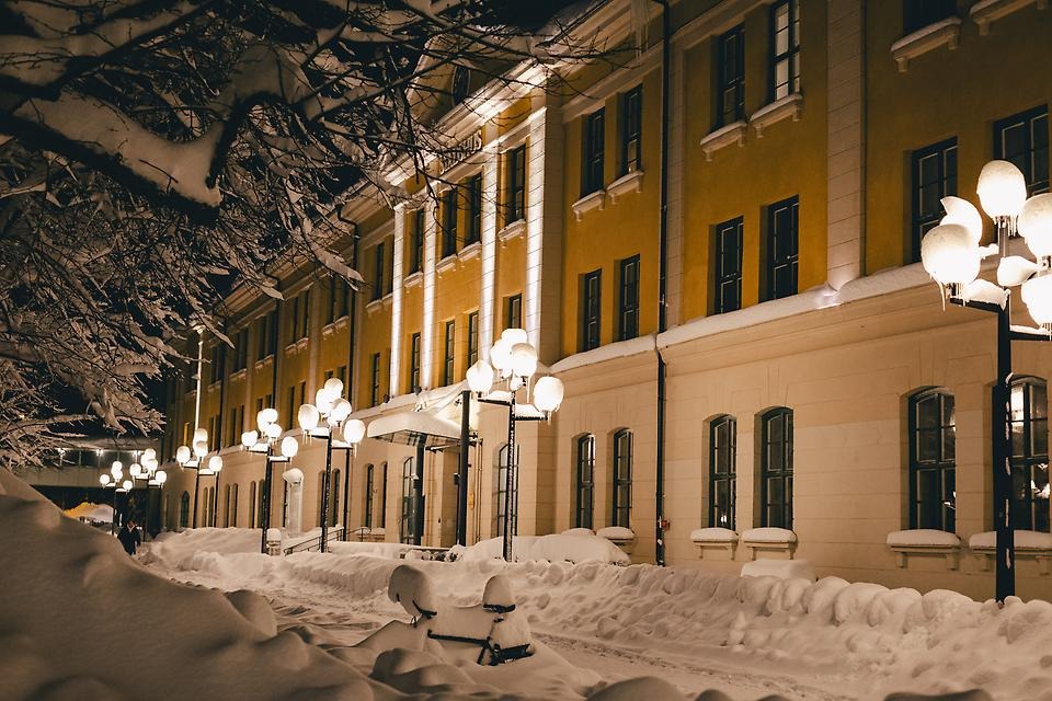 Vintrig gata med rimfrost på och julkulor i träden, med text "God jul och Gott nytt år!"