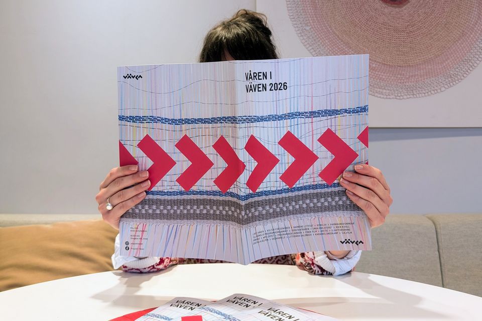 Kvinna vid ett bord läser en katalog.