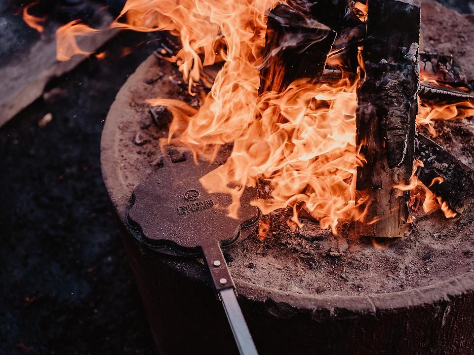 Grillring med glödande vedträn