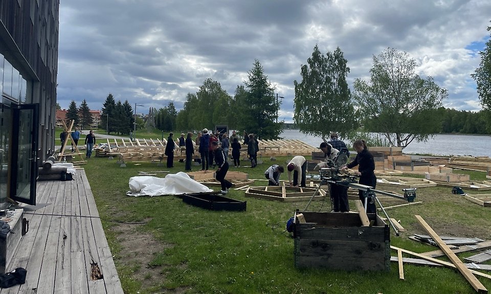 Bild av studenter vid Umeå arkitekthögskola arbetar med byggnation av möbler.
