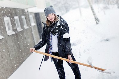 Ung kvinna skottar snö.