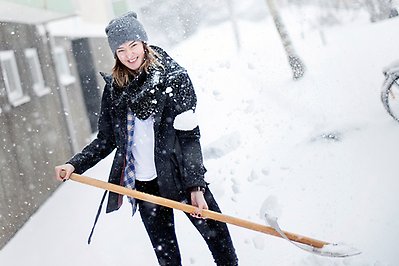 Kvinna som skottar snö